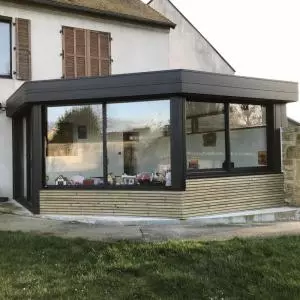 Extension d'un toit plat avec un bardage bois en clairevoie et en aluminium noir sablé à Caen