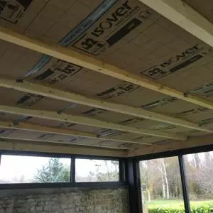 Extension d'un toit plat avec un bardage bois en clairevoie et en aluminium noir sablé à Caen