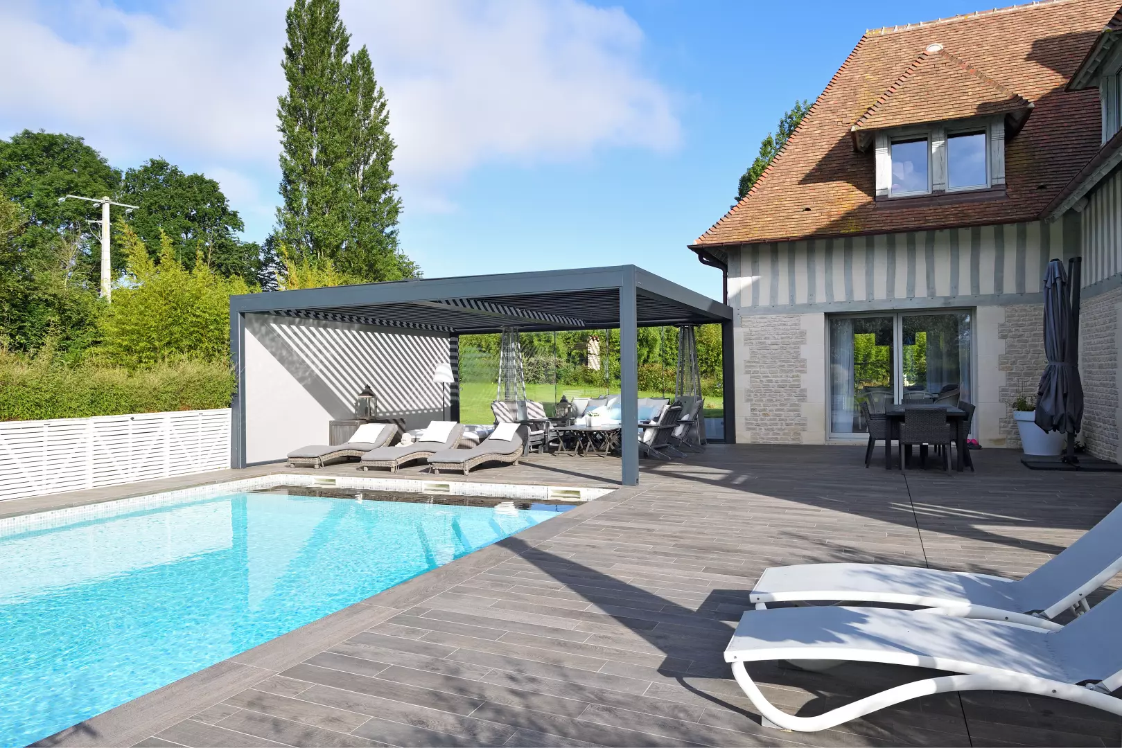 Création d'une pergola bioclimatique à lames orientables au bord d'une piscine à Deauville 